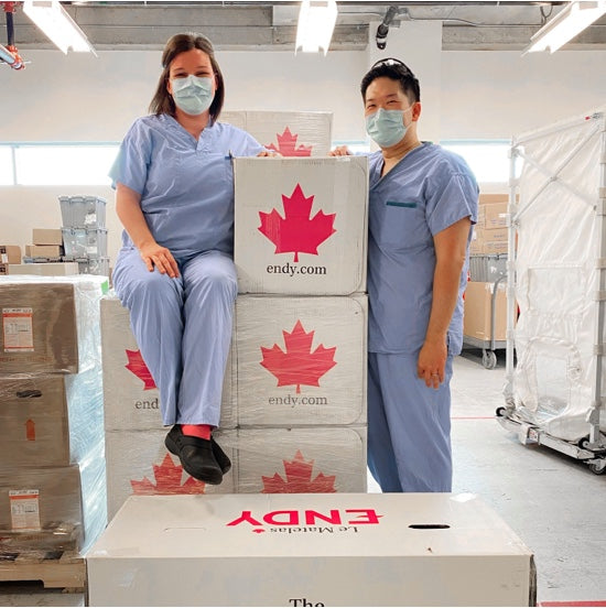 Deux travailleurs de la santé de l'hôpital d'Abbotsford portant des gommages et posant avec des boîtes de matelas Endy.